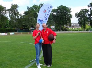 Als Dankeschön für die tatkräftige Unterstützung überreicht Rieke von der Heiden dem 2. Vorsitzenden von Preussen Leichtathletik Christoph Staufenbiel einen neuen Medizinball und einen Schleuderball.